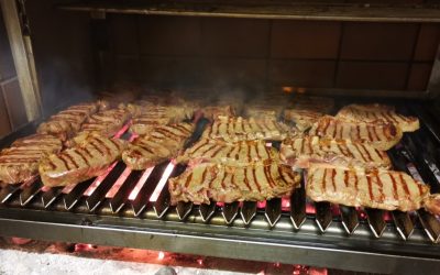 Meat cooking over the grill at Caravela